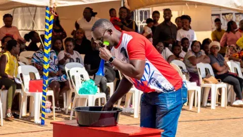 Parents vs teachers game - cup lifting with a balloon